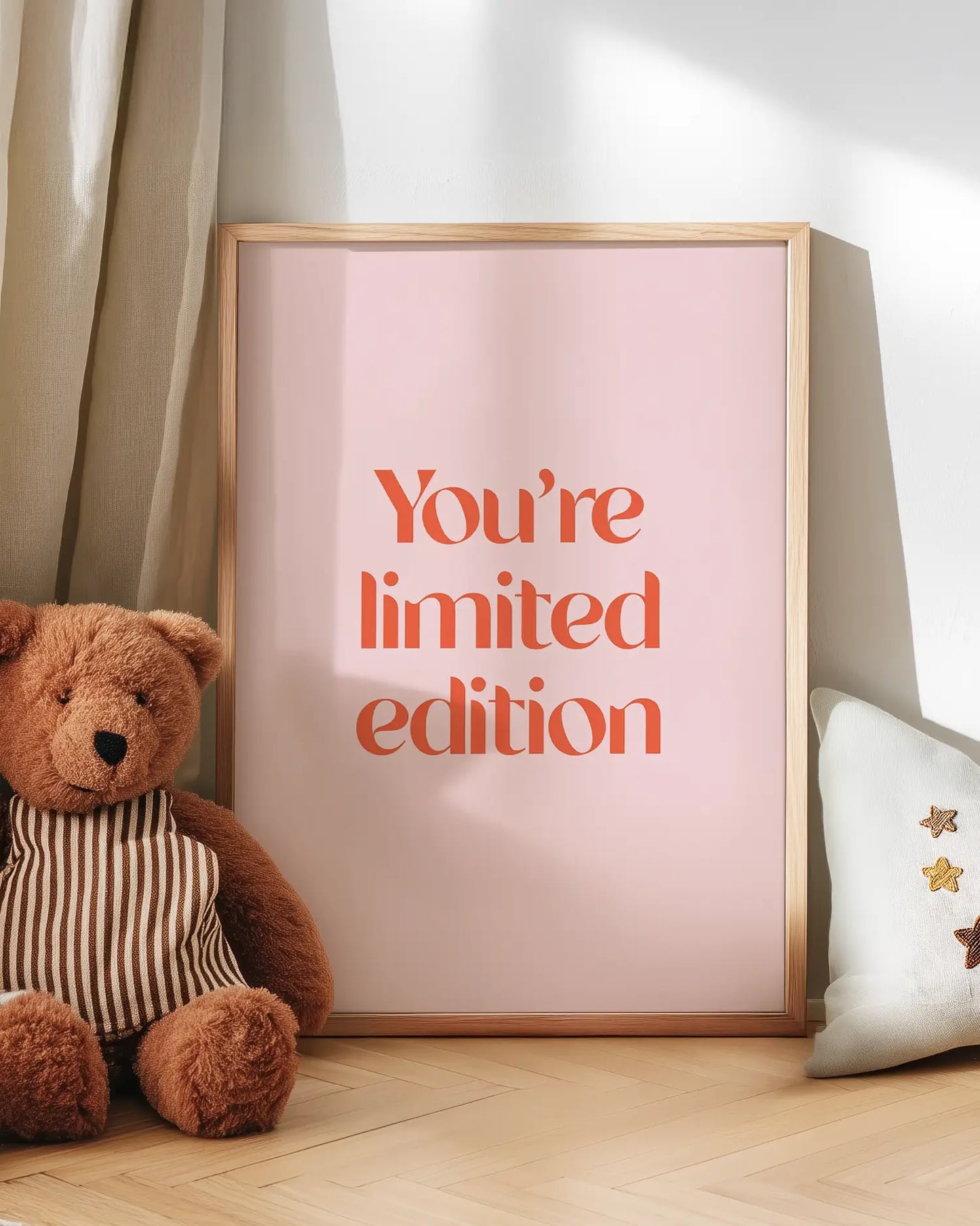 Poster with 'You're limited edition' text next to a teddy bear on a wooden floor.