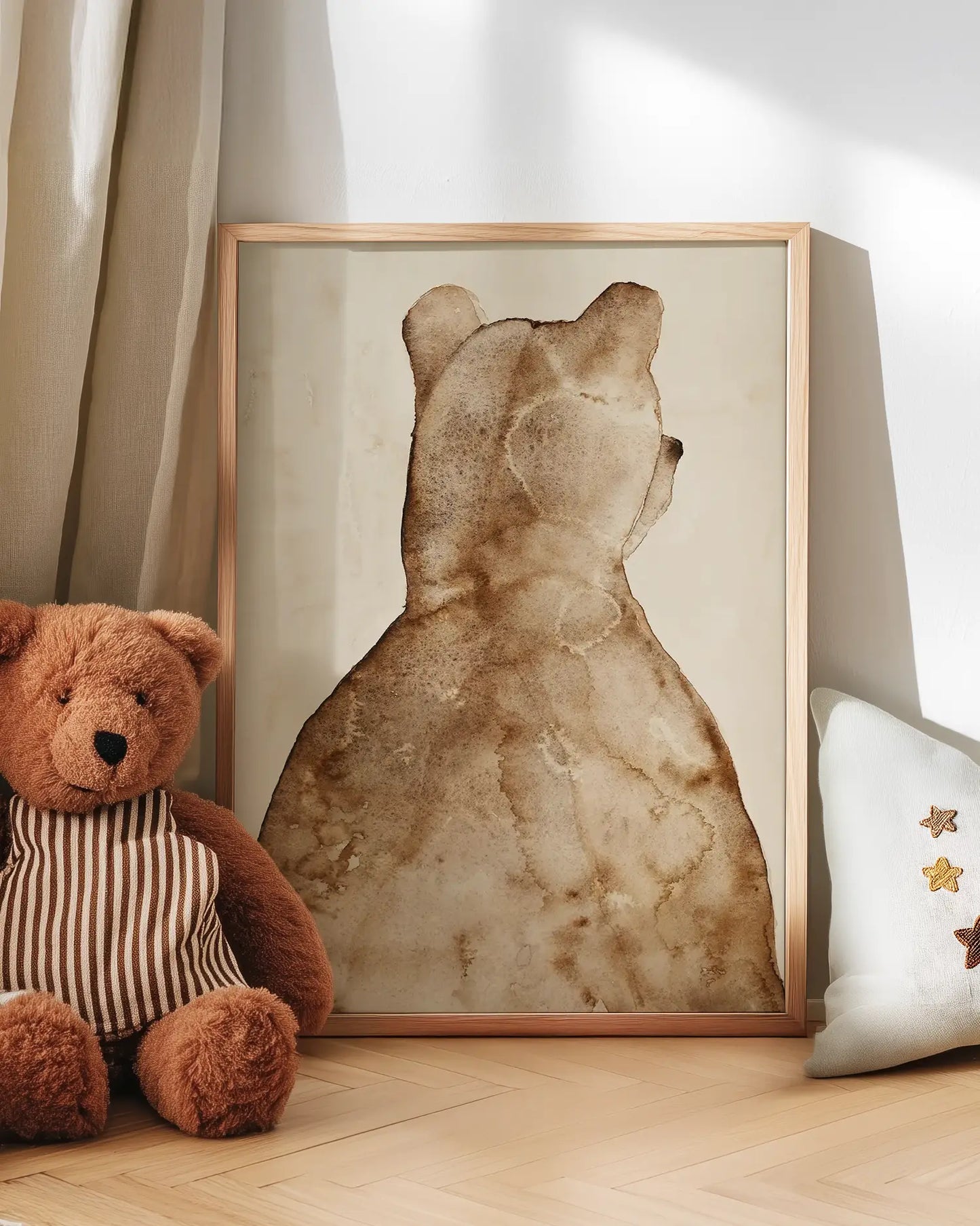 Brown bear artwork next to a teddy bear on a wooden floor.