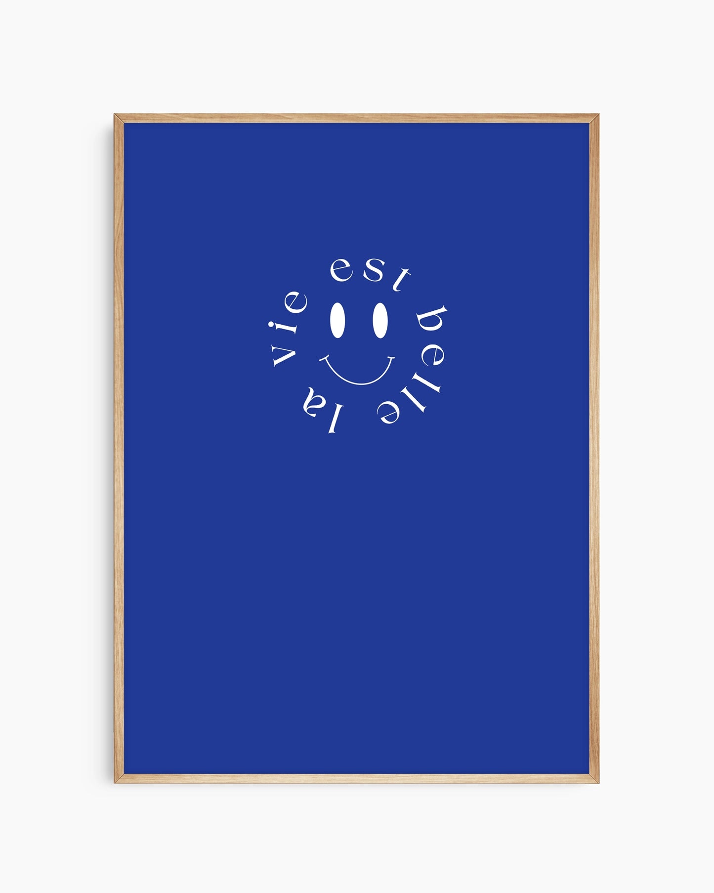 Framed artwork with a smiley face and 'La vie est belle' text on a blue background