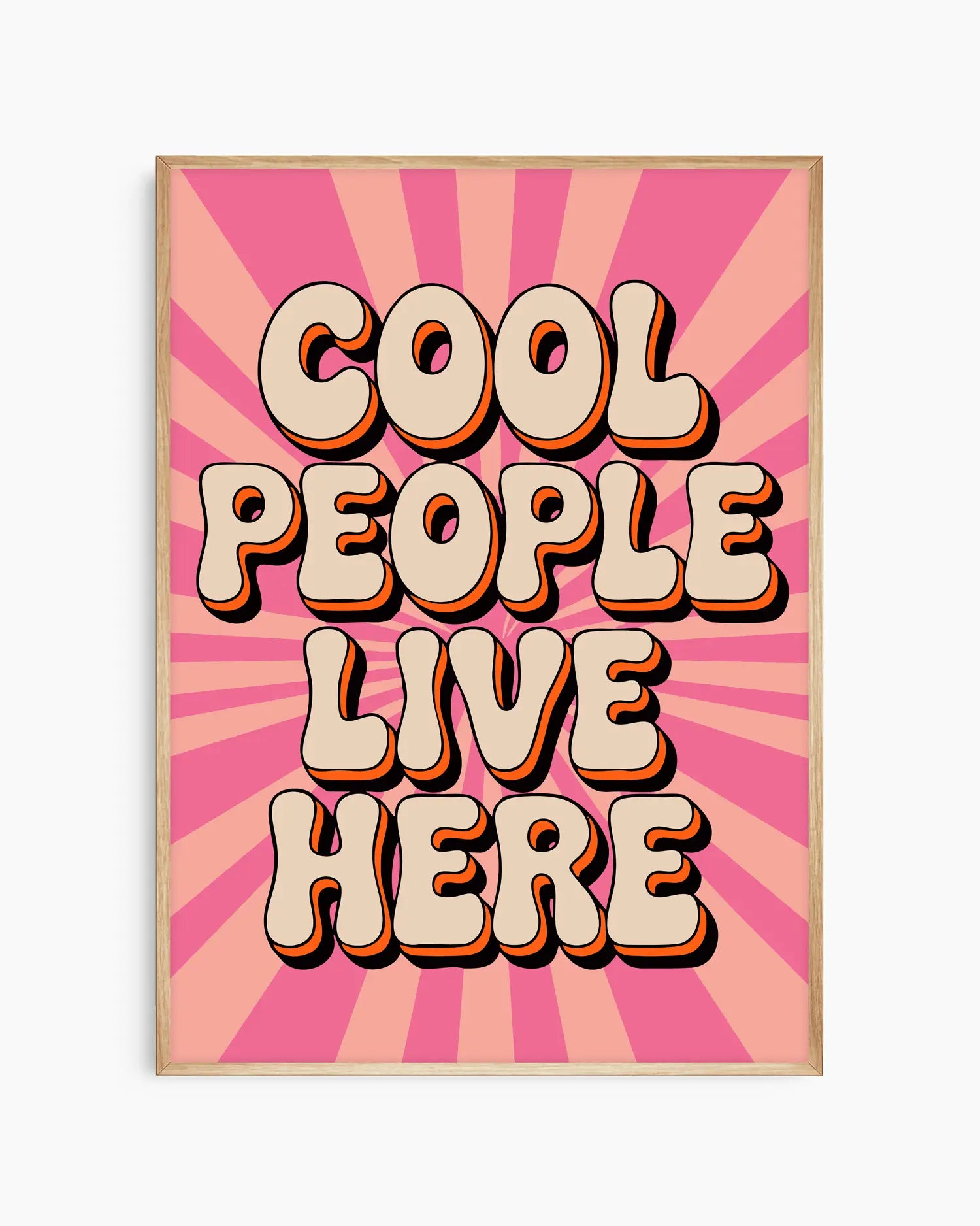 Nursery poster with 'Cool People Live Here' text on a pink sunburst background framed in an oak wooden frame.