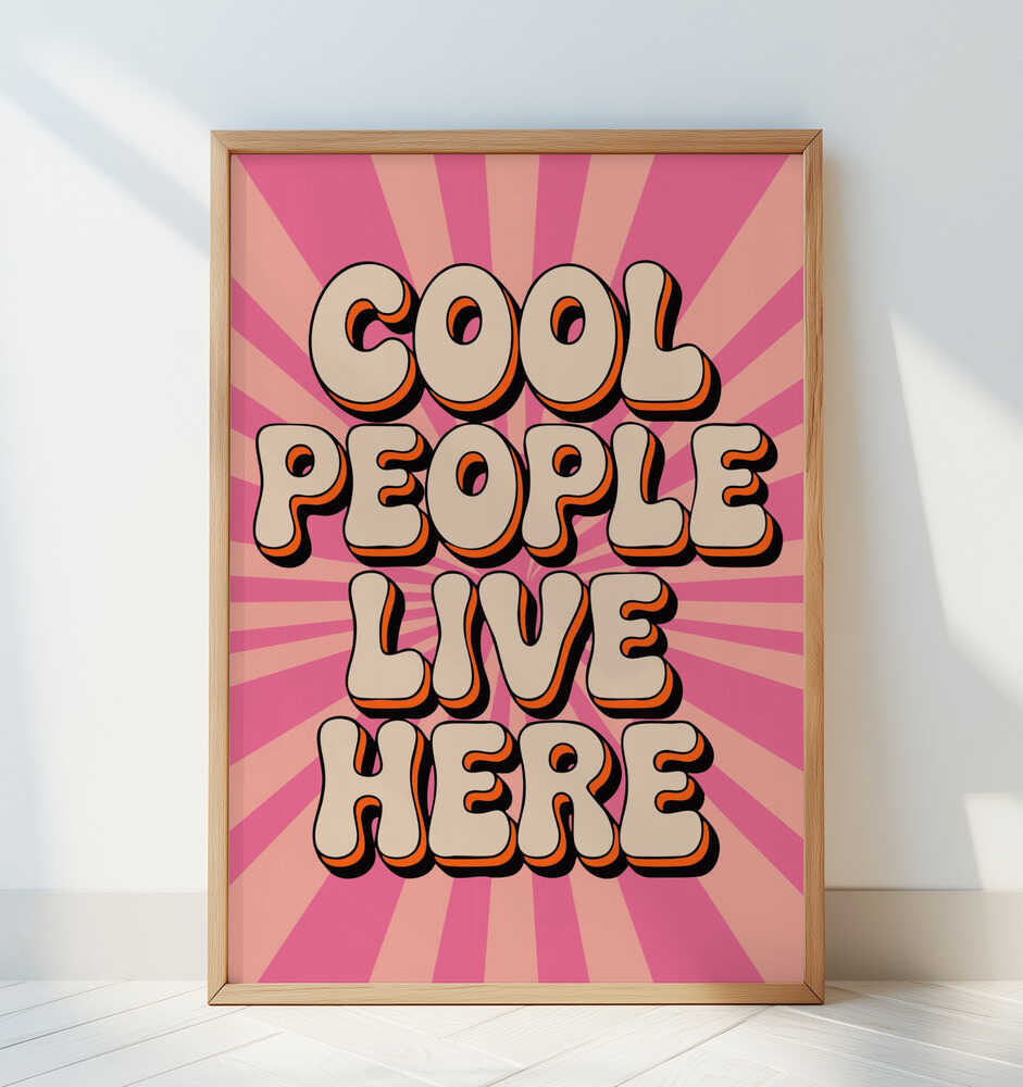 Framed nursery poster with the text 'Cool people live here' written in a 70's styled font on a pink striped background.