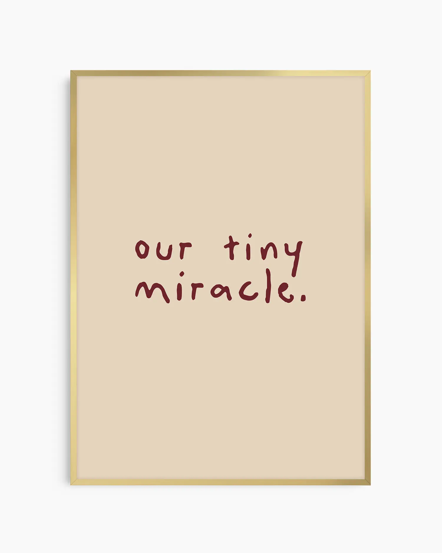 Beige nursery poster with 'our tiny miracle.' text in brown framed in a gold frame.