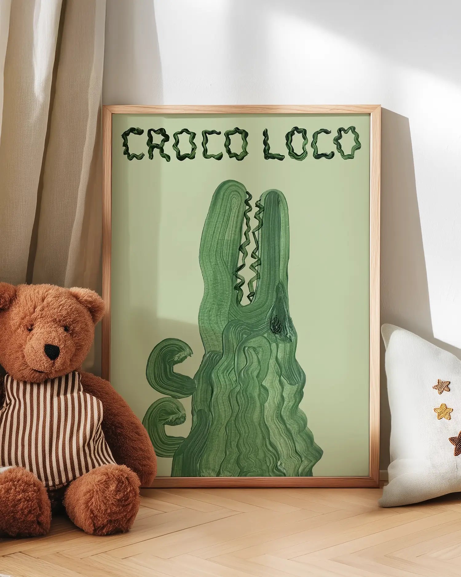 Artwork with a green crocodile illustration and 'Croco Loco' text, next to a teddy bear and pillow.