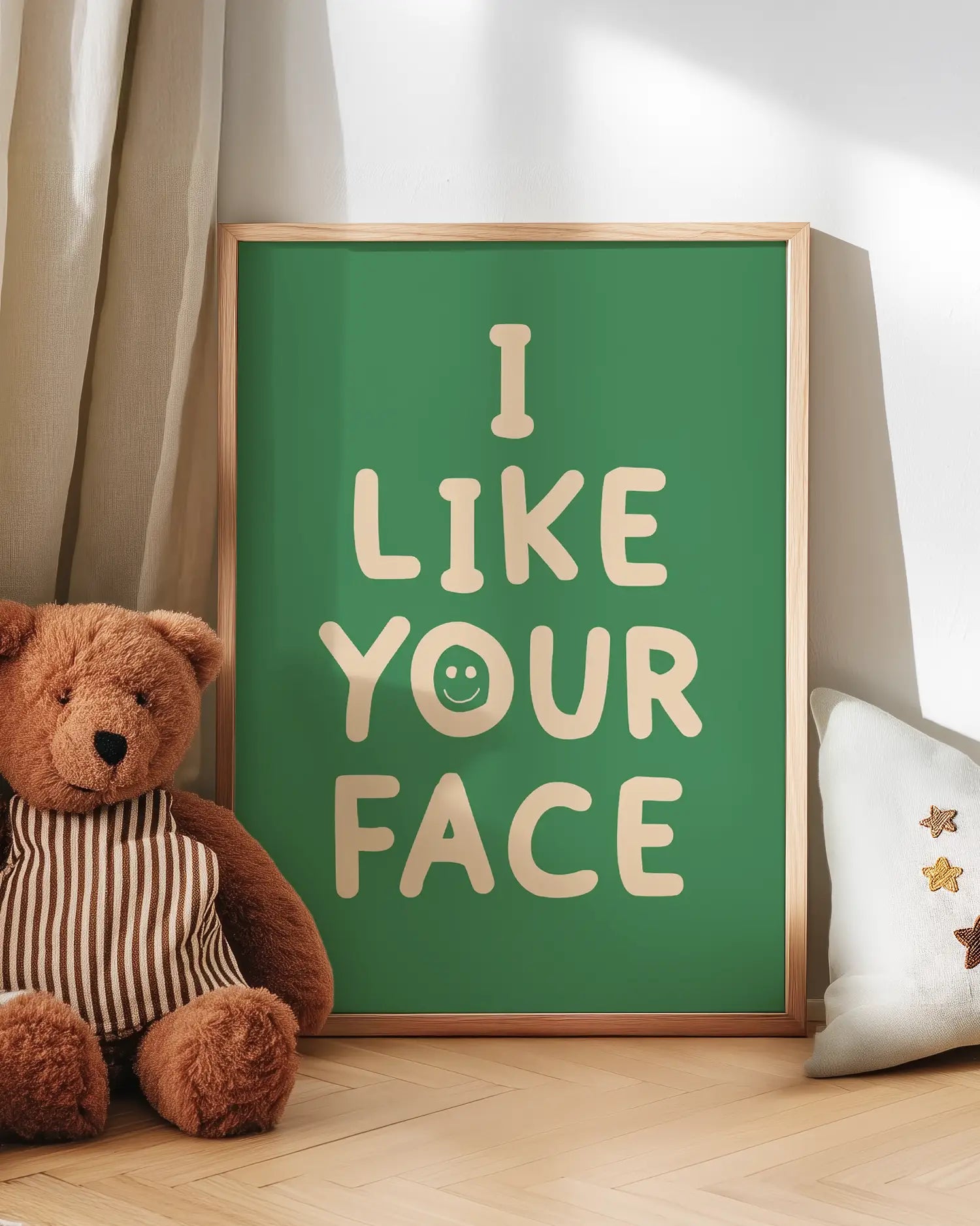 Green poster with 'I LIKE YOUR FACE' text next to a teddy bear on a wooden floor.