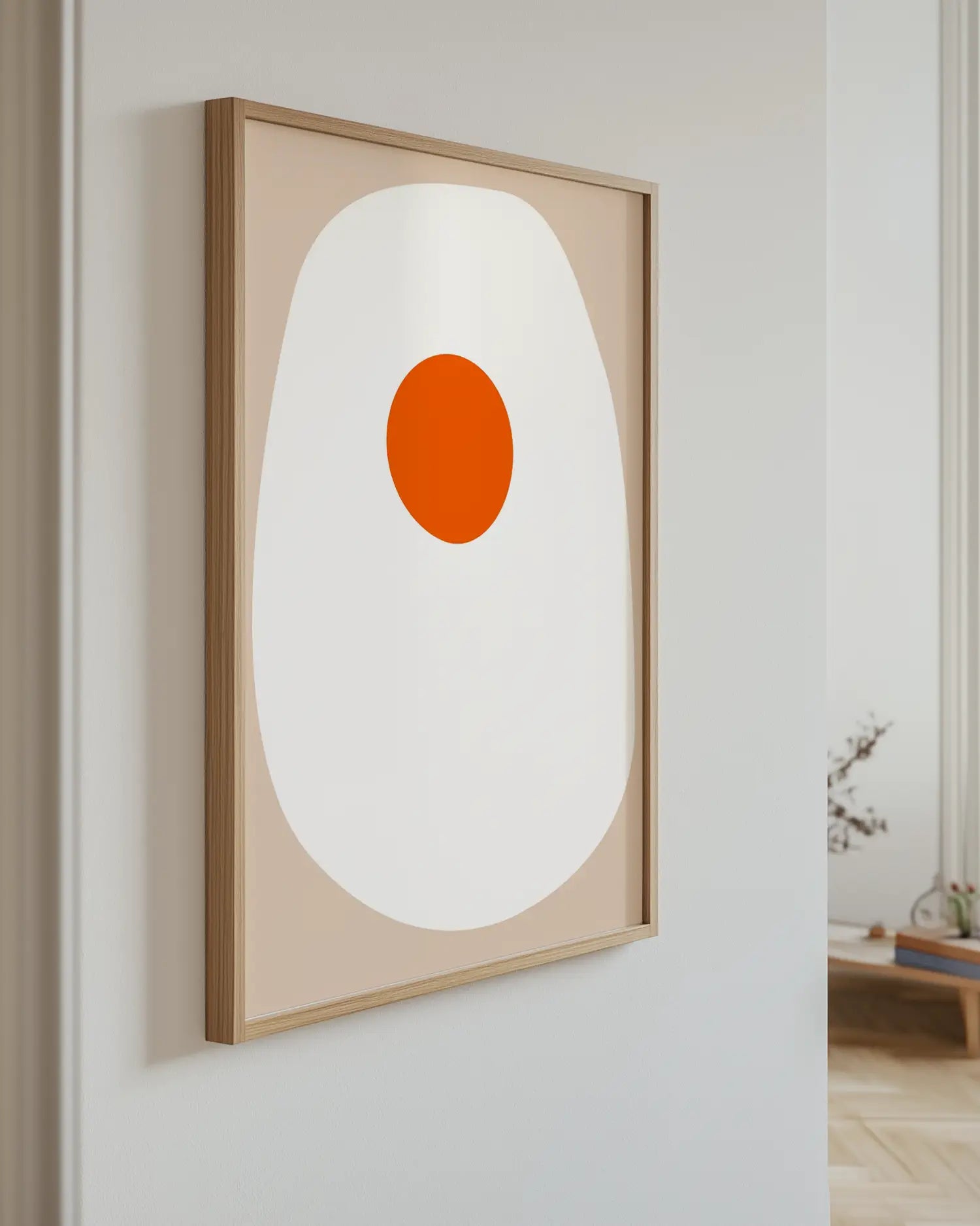 Artwork with a fried egg hanging on a white wall.