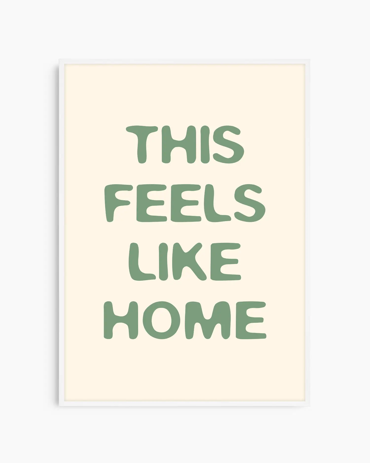 Nursery poster with the text 'This feels like home' written in green, inserted in a white wooden frame
