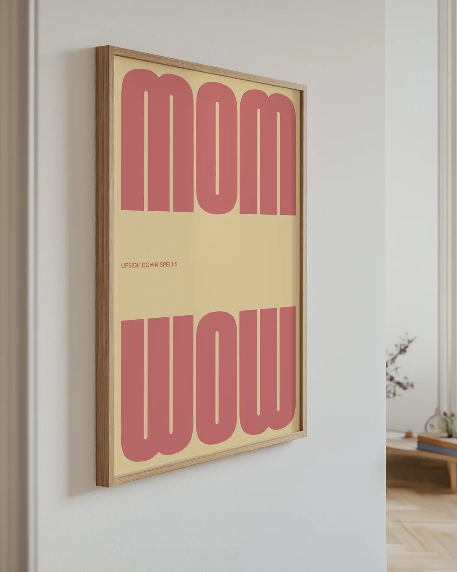 Artwork with 'MOM upside down spells WOW' in pink text hanging on the wall.